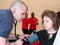 A woman gets her blood pressure taken at Jiffy Lube International's kick off for the Maintenance Partners for Life campaign.