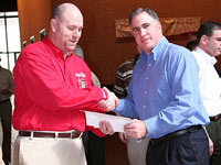 Todd McLemore of Jiffy Lube International accepts a donation.